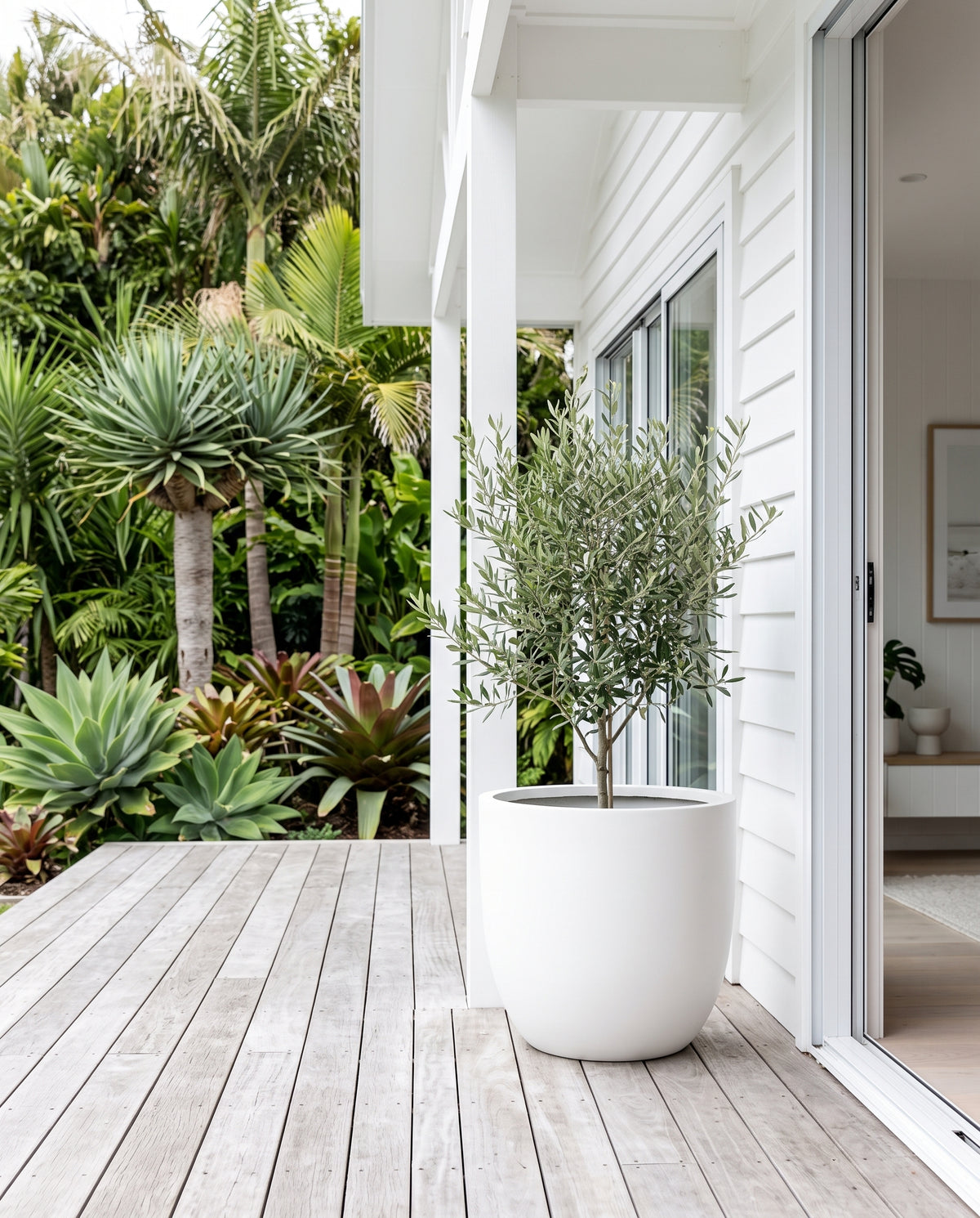 Pure white Asher egg pot styled with potted plant on outdoor verandah walkway