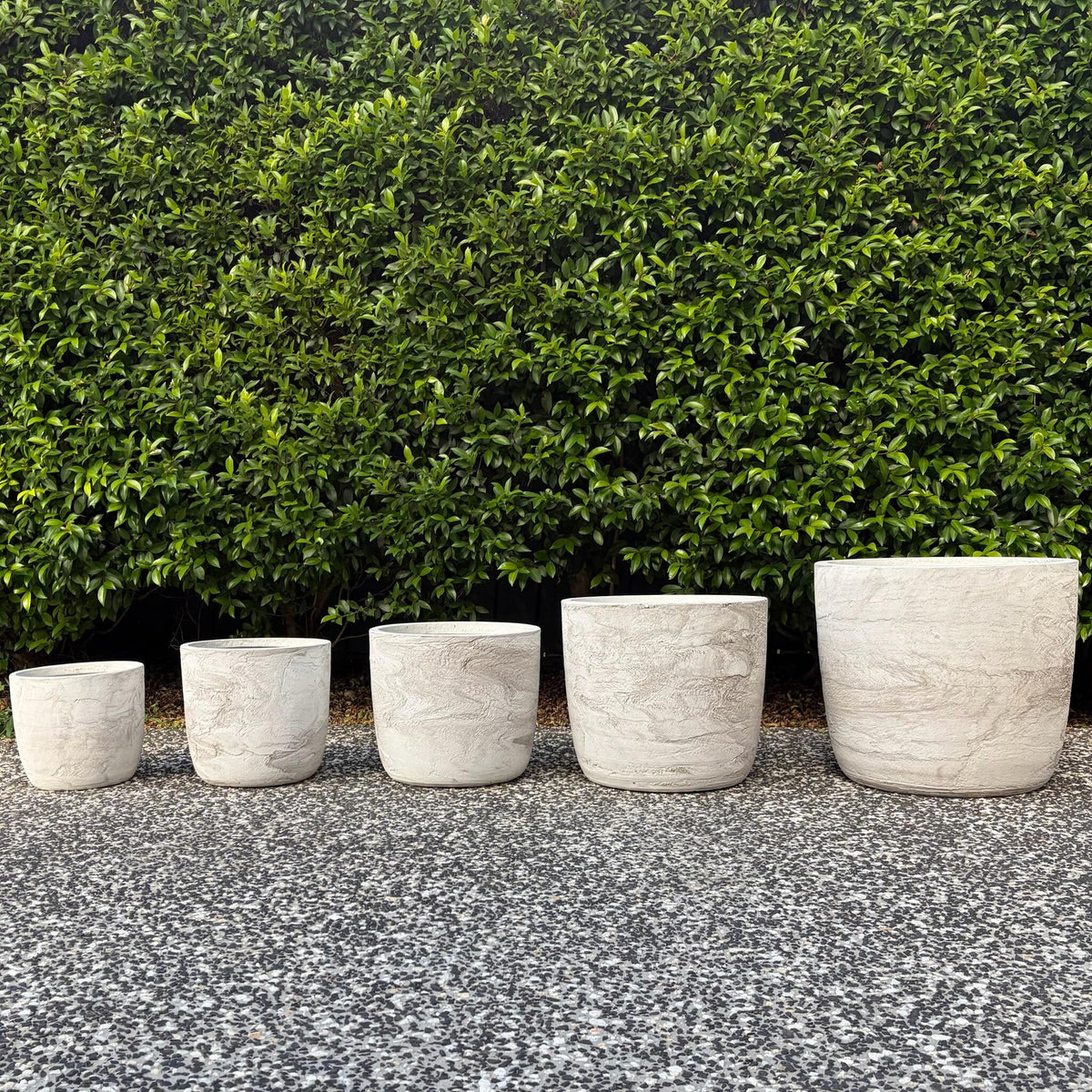 Prague White Pietra textured egg planters set of five sizes displayed outdoors on gravel