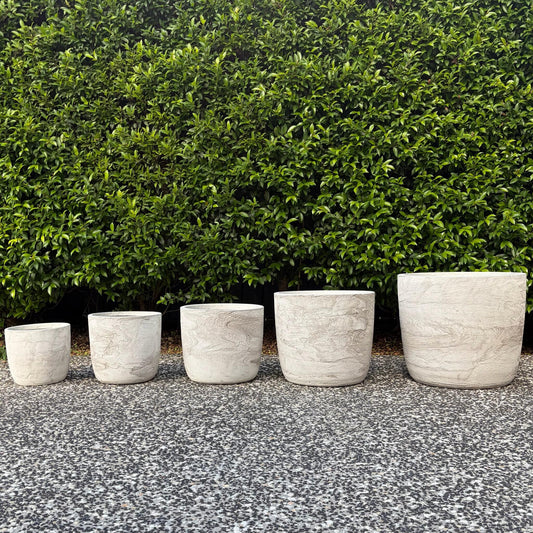 Prague White Pietra textured egg planters set of five sizes displayed outdoors on gravel