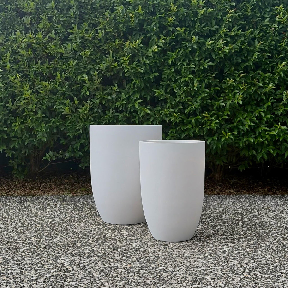 Pair of large Chambers pure white Modstone composite planters outdoors