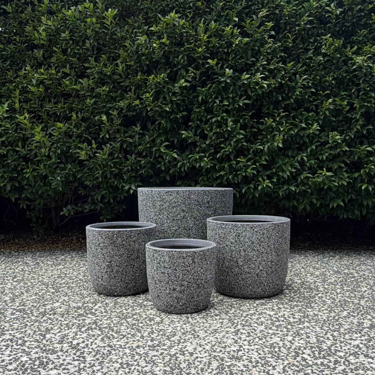 Trio cluster of Prague Grey Pebble textured planters on outdoor gravel