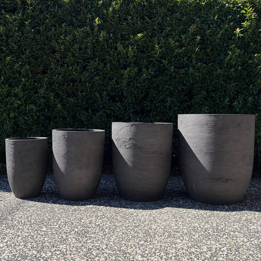 Chambers Grey Pietra textured U-pots four-pot size range displayed outdoors on gravel