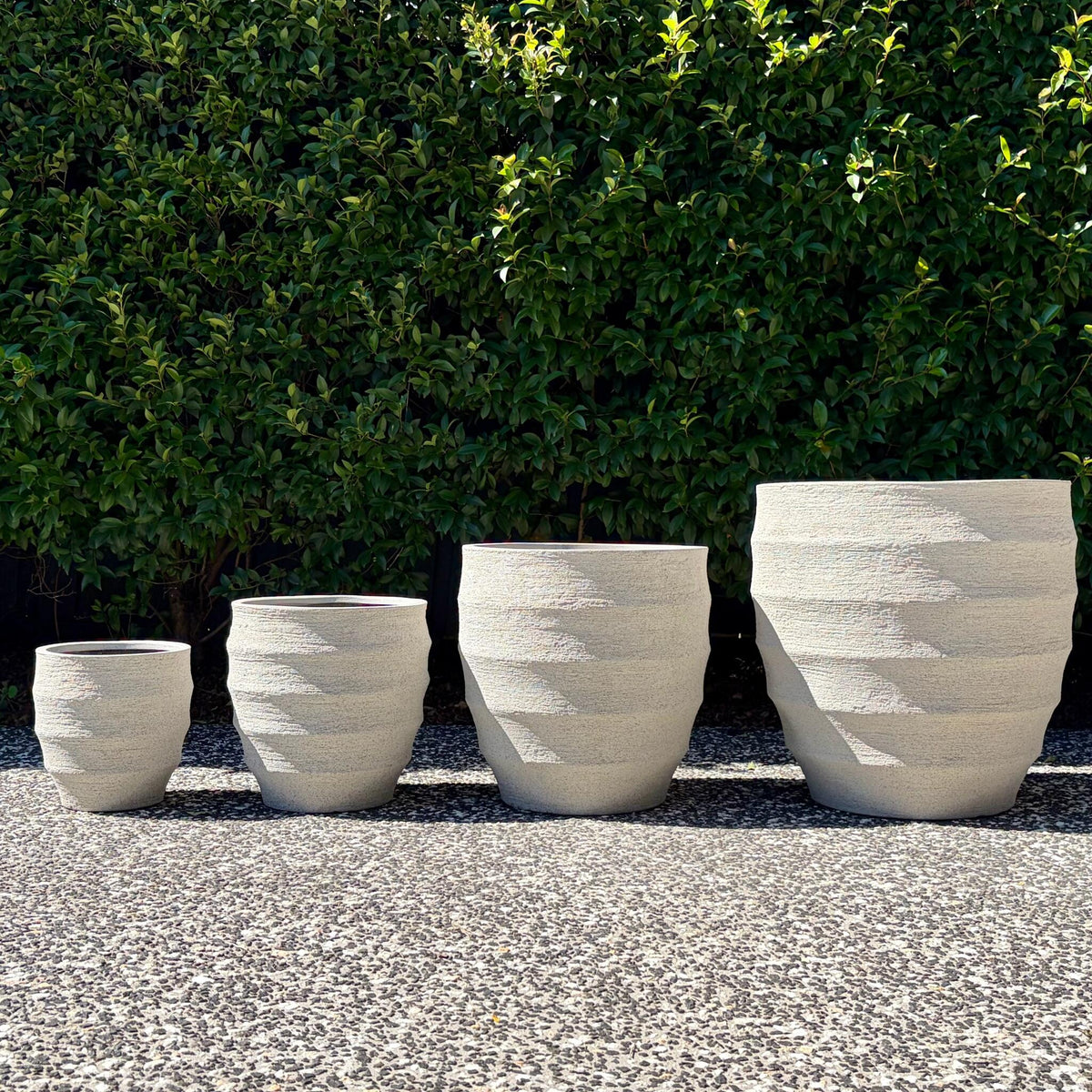 Horizons textured sand ribbed egg planters four-pot set outdoors on gravel