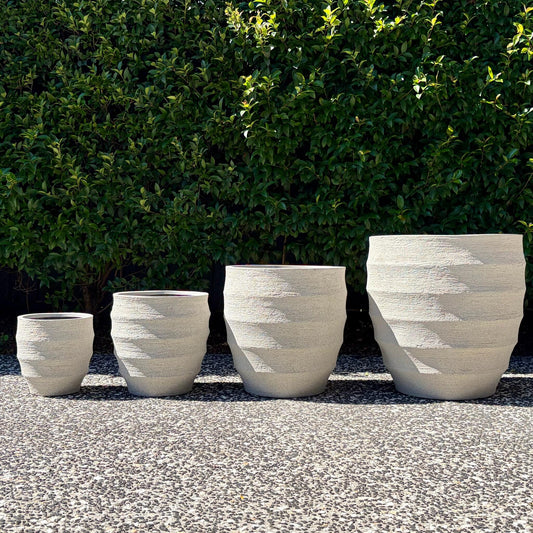 Horizons textured sand ribbed egg planters four-pot set outdoors on gravel