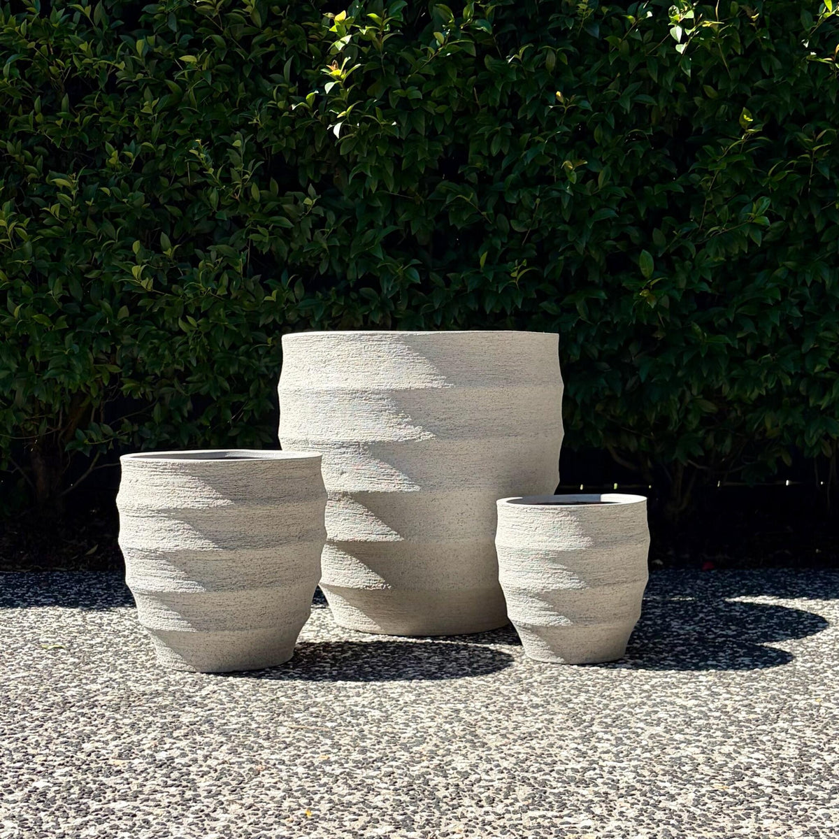 Trio cluster of Horizons textured sand egg planters highlighting horizontal ridges