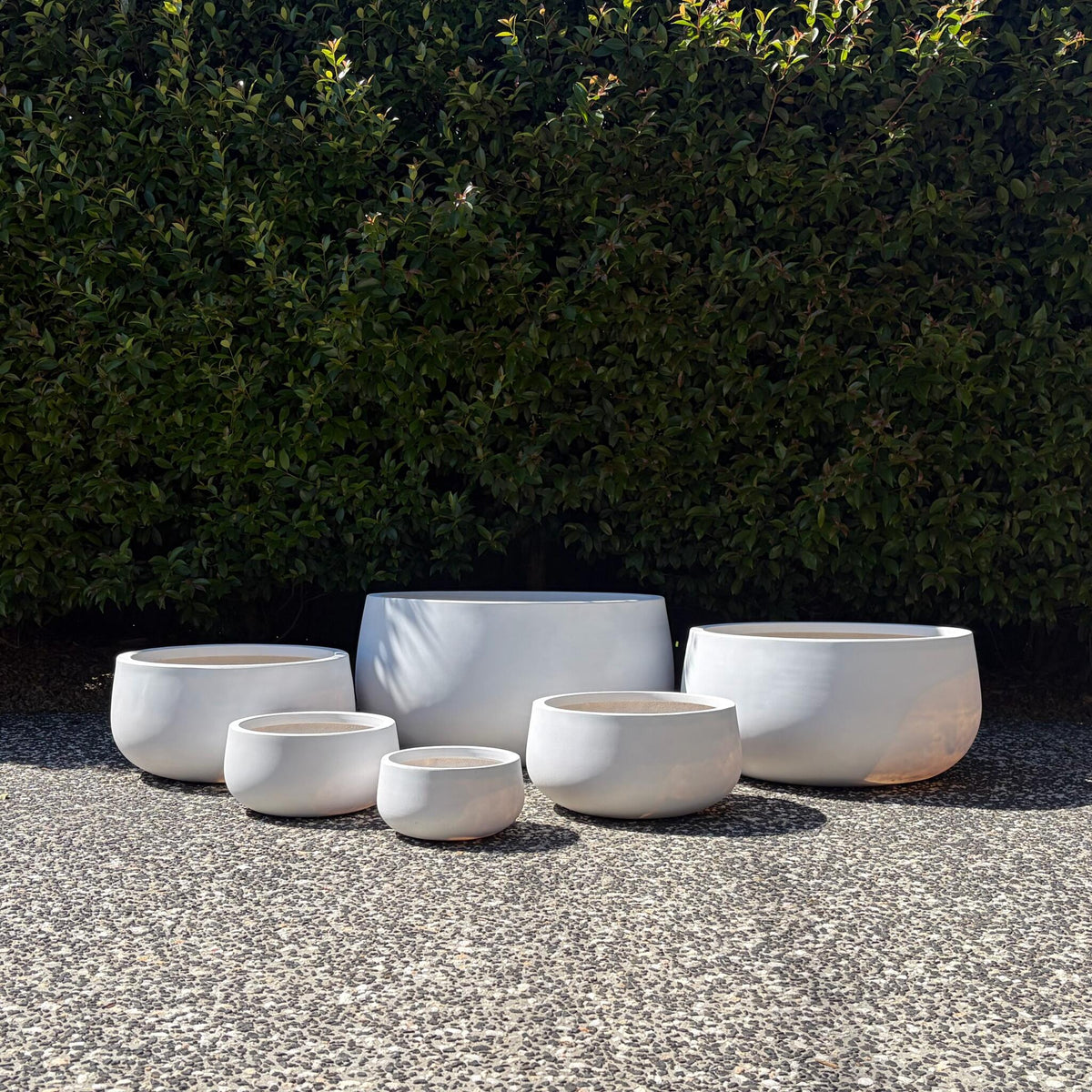 Pure white Andy bowl planters set of six sizes displayed outdoors on gravel