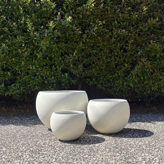 Asher pure white moon planters trio set displayed outdoors on gravel