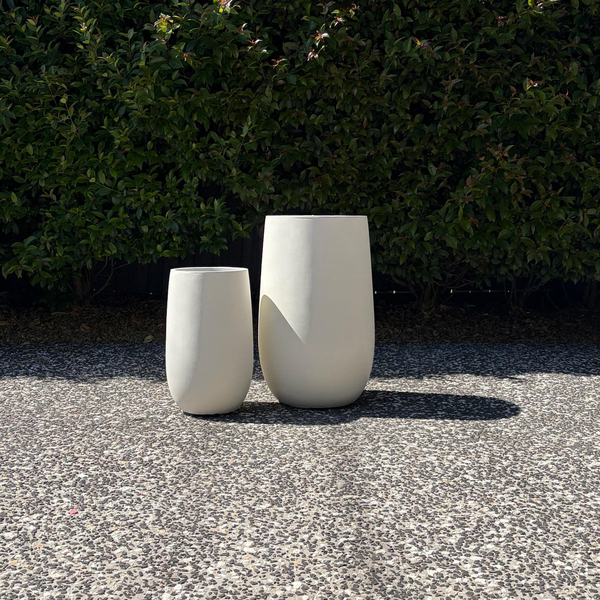 Pair of pure white Asher tall U-pots highlighting clean curved silhouette