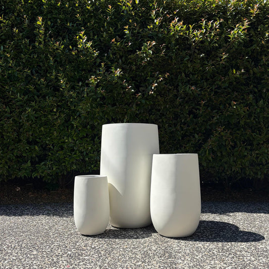 Asher pure white tall U-pots trio set in three heights displayed on outdoor gravel