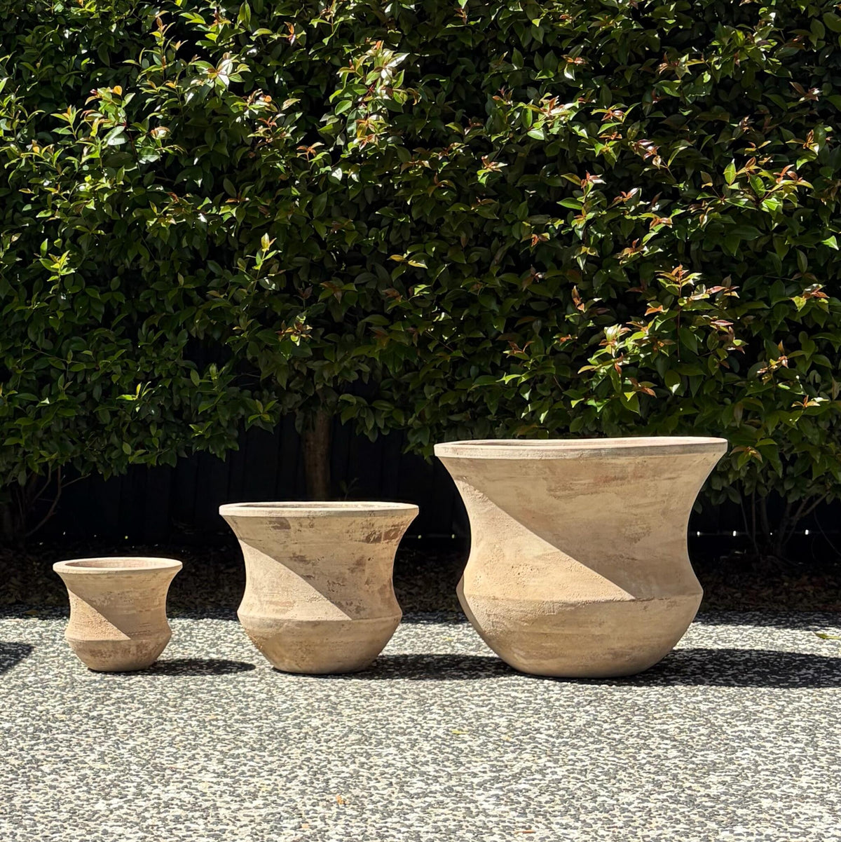 Antique terracotta Lucinda flared planters trio set displayed outdoors on gravel