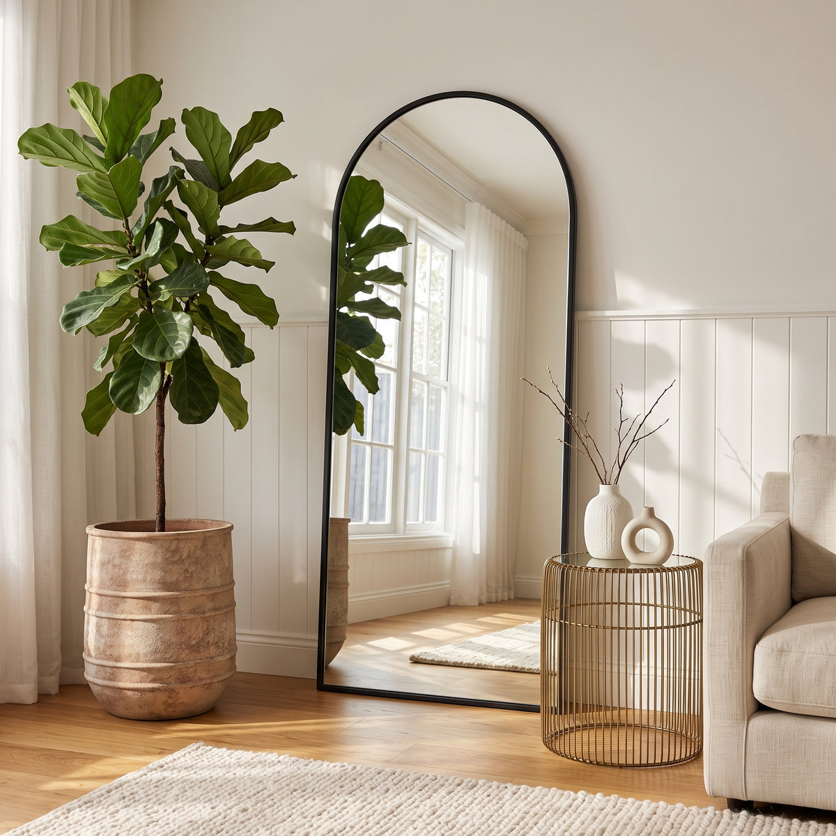 Textured antique terracotta horseshoe planter styled with indoor tree by arched mirror